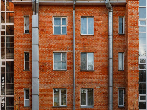 The red brick facade of avant-garde minimalist house with pipe. Detailed symmetric picture of exterior urban architecture. Element of constructivism. Kuzbassugol combine house, Novosibirsk, Gordeev. photo