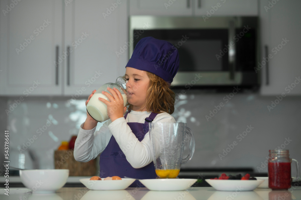 Child food preparation. Little chef preparing healthy meal. Cute kid boy in chef uniform drink milk on kitchen. Child food preparation. Little chef preparing healthy meal. Cute kid boy in chef uniform drink milk on kitchen.