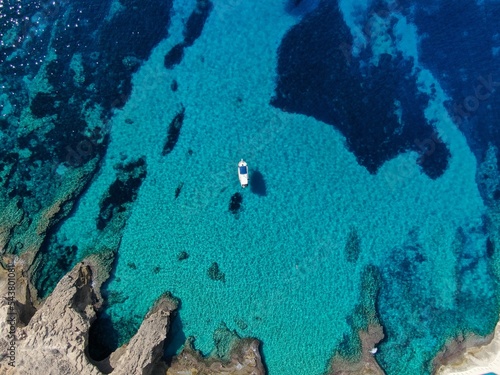 Yacht anchored in crystal clear waters of a beach of Majorca. Amazing turquoise view of the Meditteranean sea	