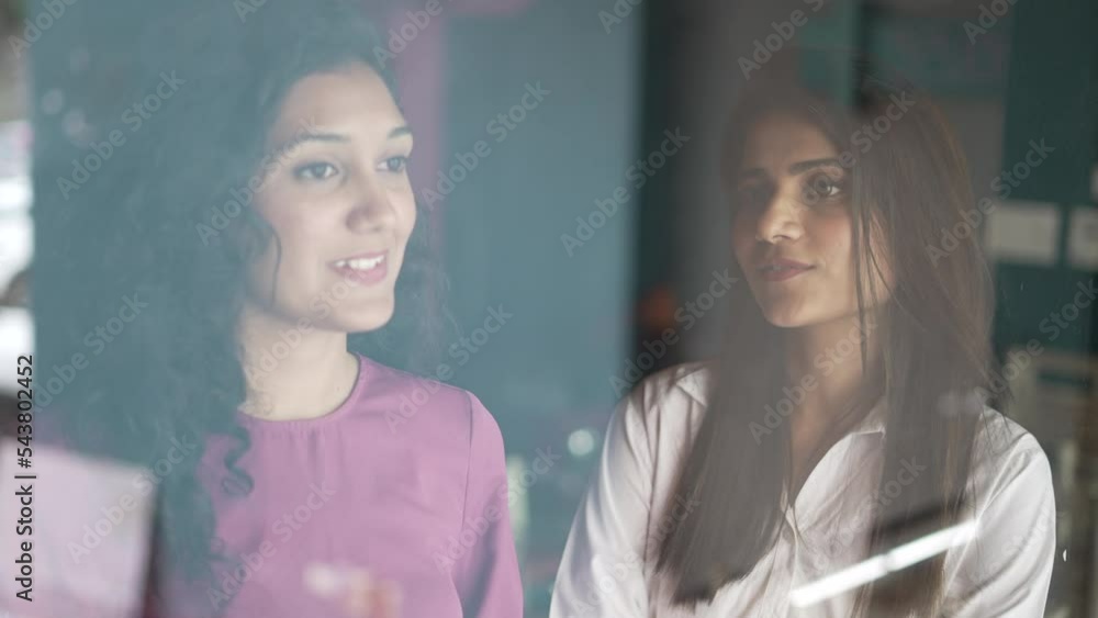 Smiling Indian woman talking to discussion in cafe. Asian female manager consulting helping client. Diverse colleagues having friendly conversation. Job applicant speaking to hr at job interview. Smiling Indian woman talking to discussion in cafe. Asian female manager consulting helping client. Diverse colleagues having friendly conversation. Job applicant speaking to hr at job interview.