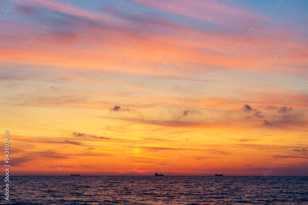 Sea horizon with ships at dusk