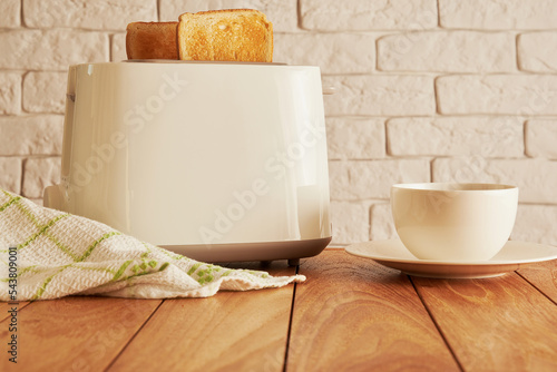 Fresh breakfast on the kitchen. Bread from toaster and coffee cup. Cooking and homeware technologies backgrounds photo