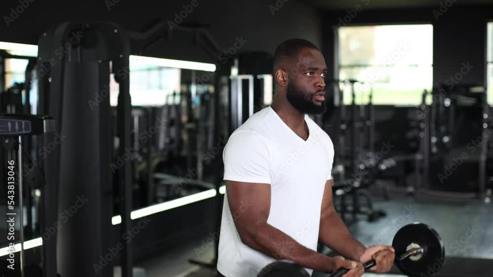 Fit and muscular african man lifting heavy barbell weight at the gym. Fit and muscular african man lifting heavy barbell weight at the gym.