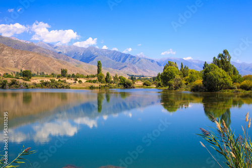 Lake in the mountains. Quiet bay in the greenery at sunset. Place for rest. Kyrgyzstan