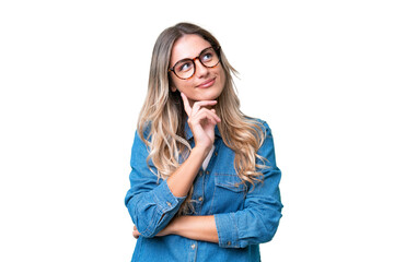 Young Uruguayan woman over isolated background thinking an idea while looking up