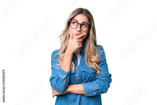 Young Uruguayan woman over isolated background having doubts and with confuse face expression