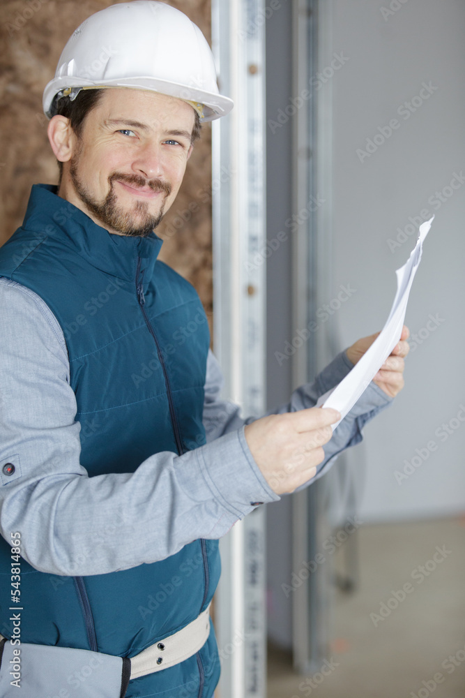 male architect holding paperwork in property male architect holding paperwork in property