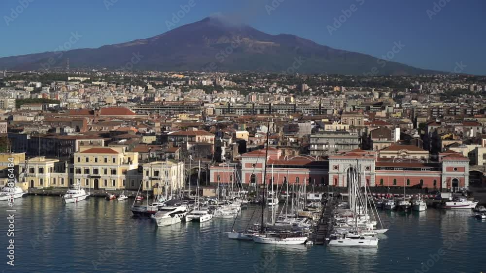 Port of Catania. Volcano Etna with white smoke and blue sky on background. Sicily, Italy Port of Catania. Volcano Etna with white smoke and blue sky on background. Sicily, Italy