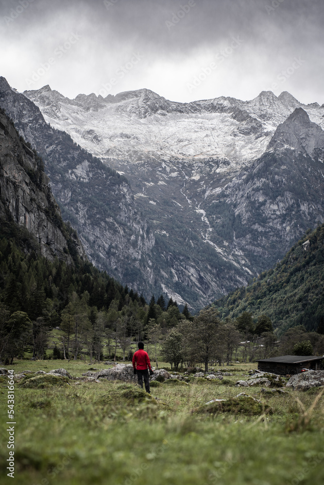 Hiker facing the Pizzo Ligoncio from the area of Val di Mello, located in Masino Valley, Northern Italy 