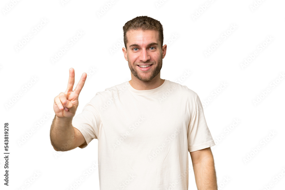 Young handsome caucasian man isolated on green chroma background smiling and showing victory sign Young handsome caucasian man isolated on green chroma background smiling and showing victory sign