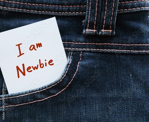 White note in jeans pocket with text label I AM NEWBIE, refers to inexperienced newcomer worker employee in the workplace,one who has just started doing activity or first jobber photo