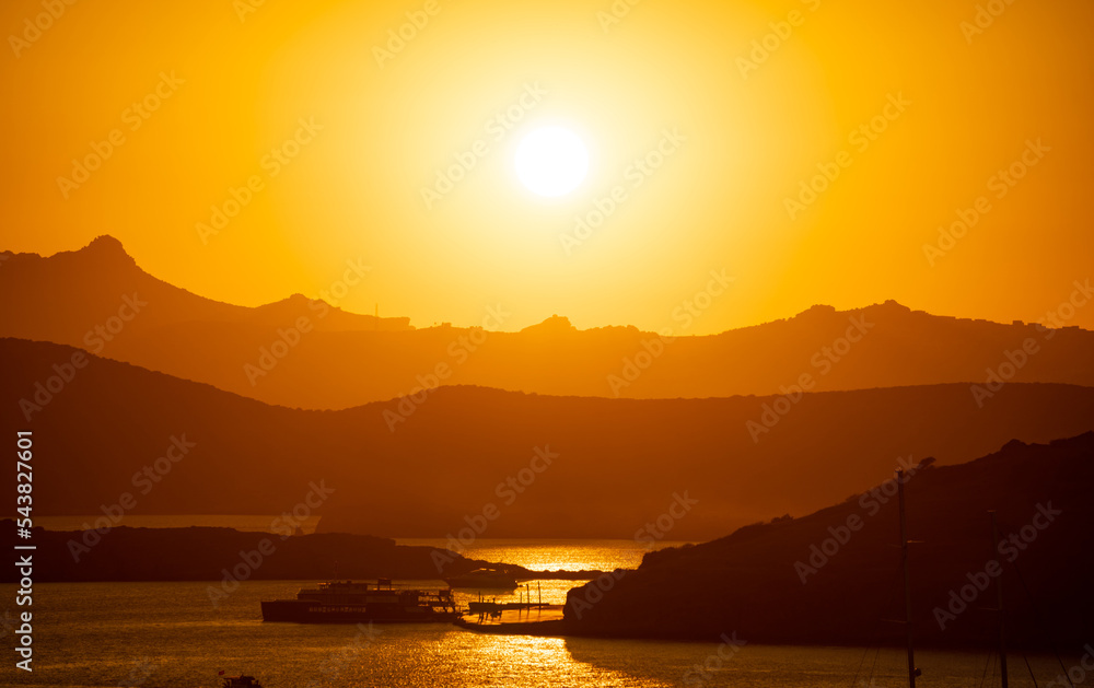 The Sun Falling Behind Mountain peak with sea foreground. A Spectacular golden Sunset 