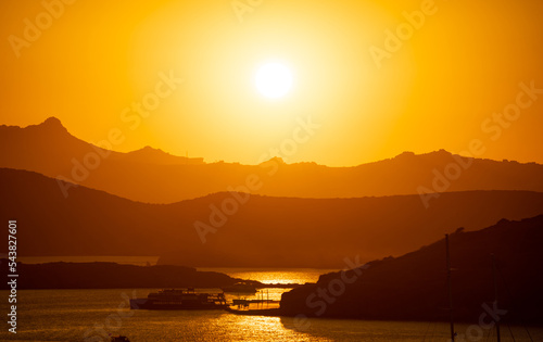 The Sun Falling Behind Mountain peak with sea foreground. A Spectacular golden Sunset  © Hladchenko Viktor