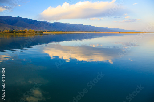 Lake in the mountains. Beautiful nature, reflection of clouds and mountains in blue water. Kyrgyzstan, Lake Issyk-Kul