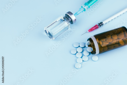 syringe with needle and vaccination, vial and pills. illegal doping in sport concept , flu vaccine or drug  addicted, wet medical. medical items background photo