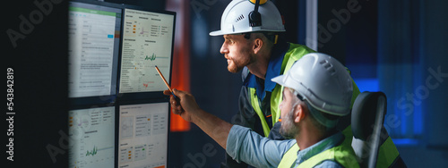 Two engineers follow assembly process uses SCADA system. Group of operators control process on product line uses industry 4.0 and digital technology on modern factory