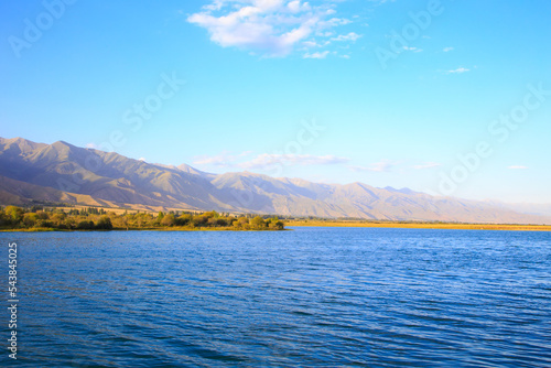 Lake in the mountains. Beautiful nature, reflection of clouds and mountains in blue water. Kyrgyzstan, Lake Issyk-Kul