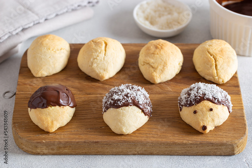 Step-by-step preparation of winter hedgehog cookies with chocolate and coconut flakes, step 4 - decorating the baked biscuits with chocolate and coconut flakes, horizontal