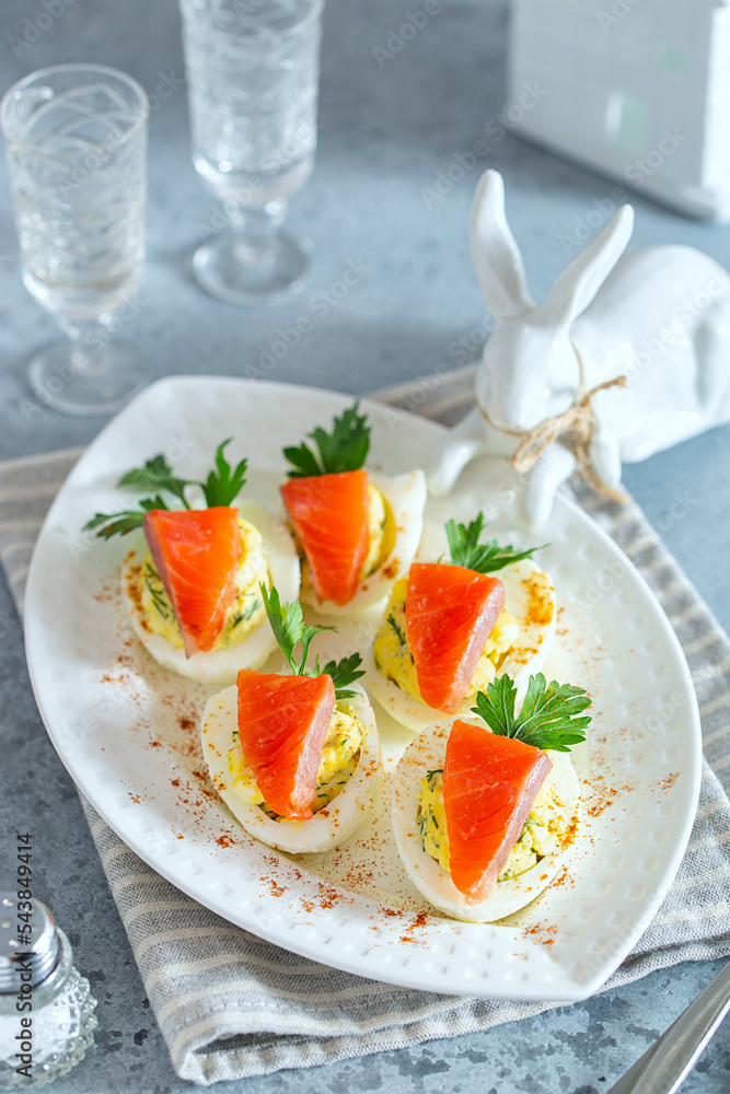 Appetizer of eggs with red fish with a decoration in the form of a carrot for the new year or Easter, selective focus Appetizer of eggs with red fish with a decoration in the form of a carrot for the new year or Easter, selective focus