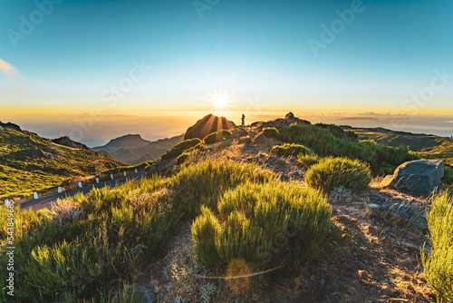 Woman enjoying beautiful mountain landscape of Pico do Ariero during sunrise. Pico do Arieiro, Madeira Island, Portugal, Europe.