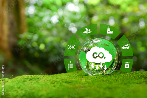 Reduction of carbon emissions, carbon neutral concept. Net zero greenhouse gas emissions target. Reducing carbon footprint concept. Decreasing CO2 emissions target symbol on green view background.