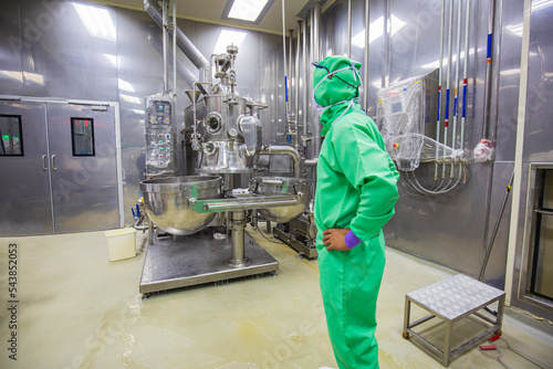 Male operation green protective clothes process in a food factory. the processing production line in a factory.
