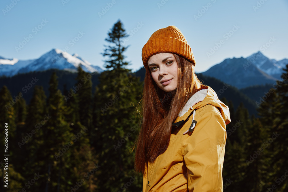 Young woman tourist portrait in yellow raincoat traveling and hiking in the mountains. Hiking in nature in the sunset Young woman tourist portrait in yellow raincoat traveling and hiking in the mountains. Hiking in nature in the sunset