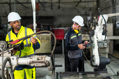 Obraz na płótnie Robotics control engineers solve problems control panel of robot for setting programming for industrial robot arm controller in production plant factory w salonie
