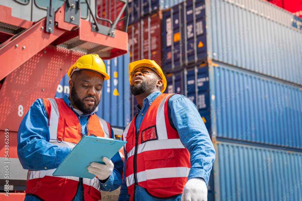 Obraz premium Two male engineers in a container shipping company Consulting to check the order for the container that is responsible