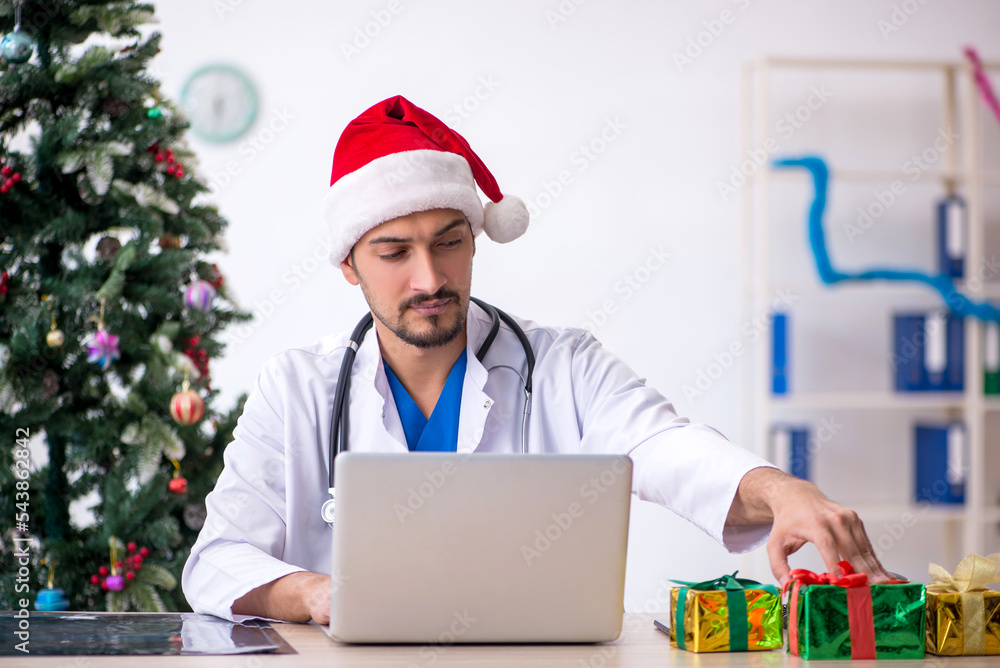 Young male doctor celebrating Christmas at the hospital Young male doctor celebrating Christmas at the hospital