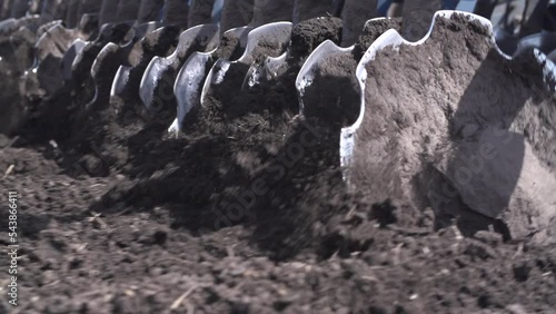 Farmer in tractor preparing land with seedbed cultivator as part of pre seeding activities in early spring season of agricultural works at farmlands. Cultivated field Agronomy farming husbandry