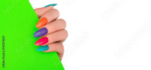 Female hand with colorful nail design. Glitter nail polish manicure: purple, green, pink and orange hold green paper on transparent background. Png nails.