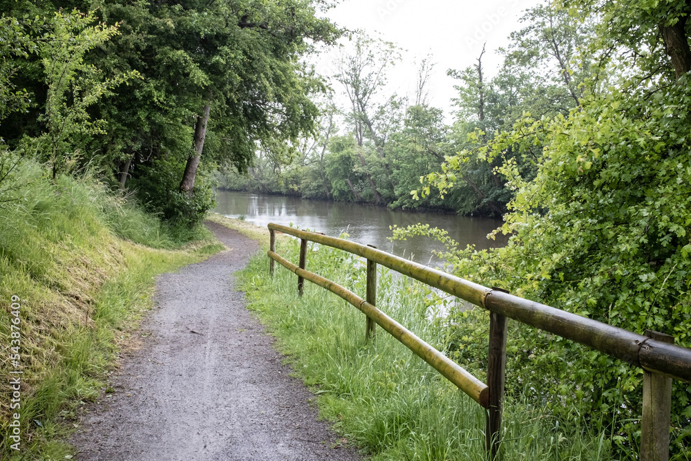 Path for walking and cycling, with wooden railings to prevent falling into the river. Landscape.