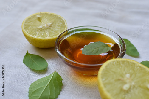 Indian Ayurvedic Kadha or Karha or health tonic for fighting seasonal infections, made using ginger, tulsi, honey and lemon on white background. Selective focus photo