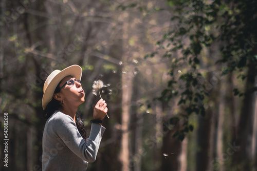 mujer con sombrero disfrutando de la naturaleza en bosque photo