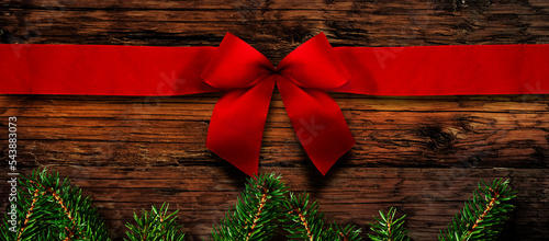 Rote Weihnachtsscheife auf einer alten Holzwand
