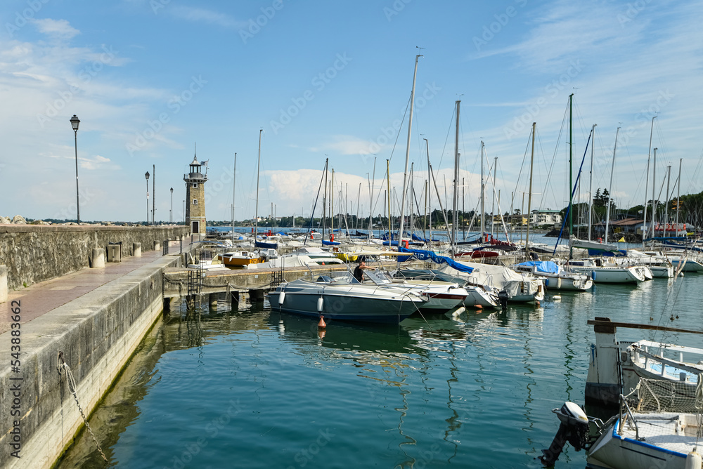 sailing boats and speedboats are moored in the port of Lake Garda Italy