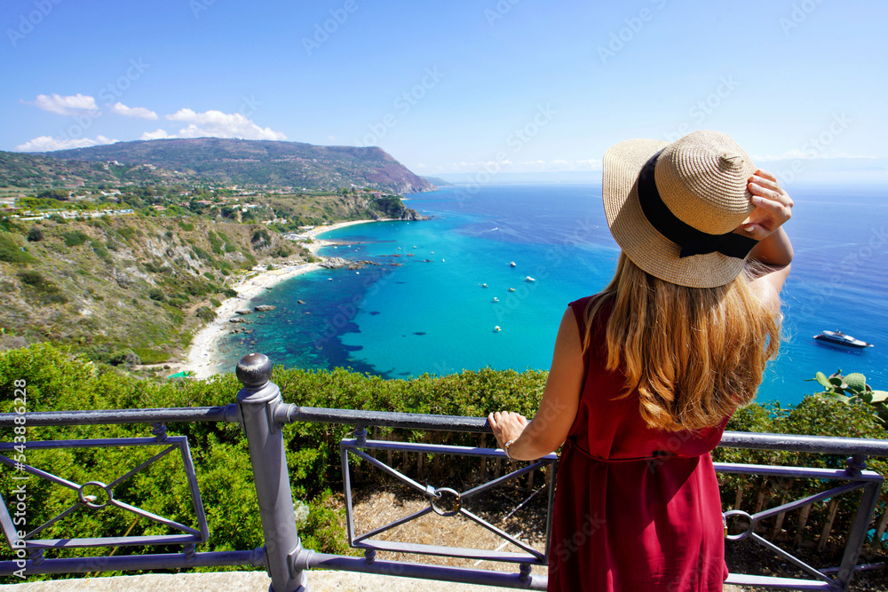 Holidays in Italy. Rear view of traveler woman in Capo Vaticano on Coast of the Gods, Calabria, Italy. Holidays in Italy. Rear view of traveler woman in Capo Vaticano on Coast of the Gods, Calabria, Italy.
