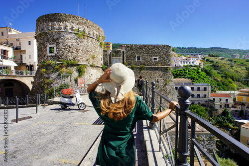Tourism in Calabria. Back view of beautiful woman in Pizzo with Murat Aragon Castle in Pizzo, Calabria, Italy. photo