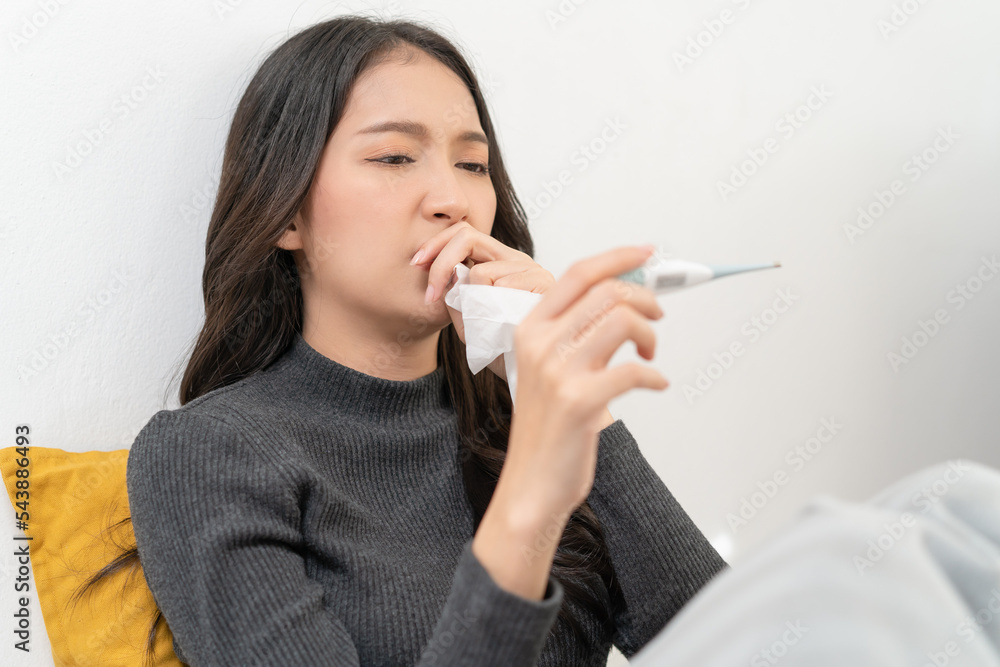 Woman measuring temperature her body on the bed. person got fever lying on the bed. Woman measuring temperature her body on the bed. person got fever lying on the bed.