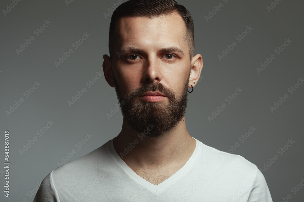 Male beauty concept. Portrait of proud charismatic active 30-year-old man posing over dark gray background looking at camera. Perfect haircut. Hipster style. Close up. Studio shot Male beauty concept. Portrait of proud charismatic active 30-year-old man posing over dark gray background looking at camera. Perfect haircut. Hipster style. Close up. Studio shot