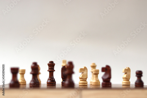 A chessboard with walking figures placed on a white background. Strategy game.