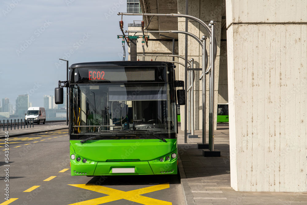 Electric bus at a stop is charged by pantograph. Clean mobility
