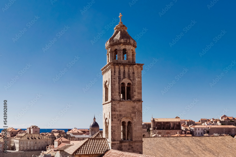 Detail of church and bell tower of the Franciscan church in clear sunny day at sunset in Dubrovnik, Croatia. Religious or travel or architecture background. 