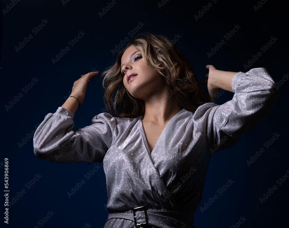 teenage girl in a silver dress dancing at a party teenage girl in a silver dress dancing at a party