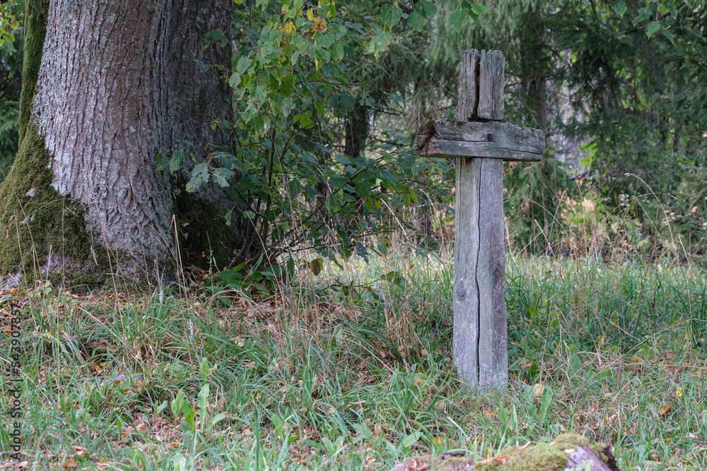 Leaning old wooden cross in abandoned cemetery Leaning old wooden cross in abandoned cemetery