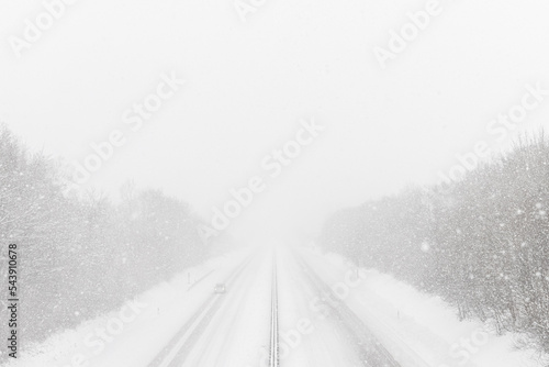 Heavy snowfall on the highway. Dangerous winter weather with low visibility. Small car on the freeway © Gaschwald