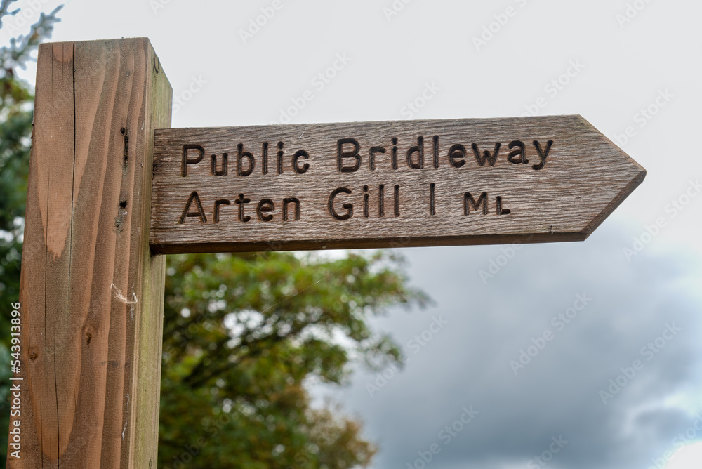 Wooden signpost for a public bridleway to the Arten Gill viaduct near Sedbergh in the Yorkshire Dales in England, UK.