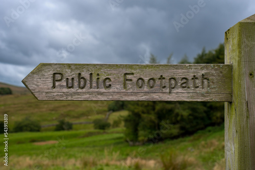 Wooden signpost "Public Footpath" in the Deepdale in the Yorkshire Dales in England, UK.