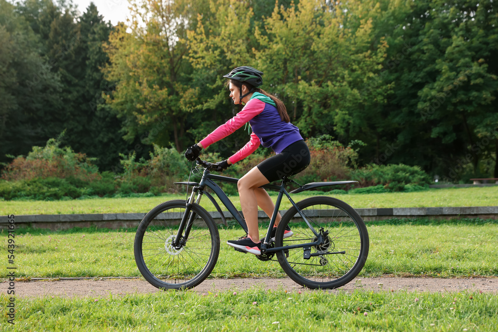 Young woman riding bicycle on road outdoors Young woman riding bicycle on road outdoors
